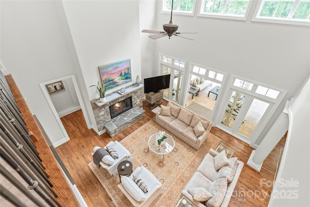 6831 Conservatory Ln, Charlotte, NC 28210 - living room featuring a high ceiling, plenty of natural light, a stone fireplace, and wood finished floors
