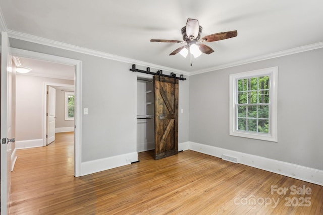 500 Peigler St NW Unit 1 & 2, Concord, NC 28027 - empty room with light wood-style flooring, a ceiling fan, ornamental molding, a barn door, and baseboards