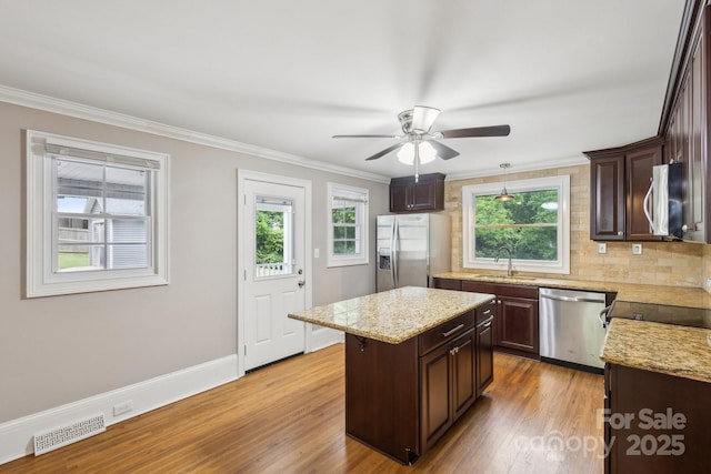 500 Peigler St NW Unit 1 & 2, Concord, NC 28027 - kitchen with appliances with stainless steel finishes, dark brown cabinetry, tasteful backsplash, light wood finished floors, and ornamental molding