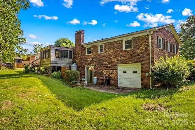 157 E Meadowview Dr, Statesville, NC 28625 - back of property with a garage, a chimney, brick siding, a yard, and a sunroom