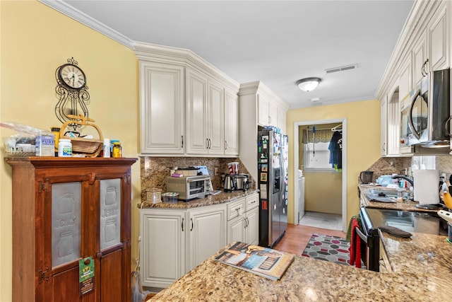 157 E Meadowview Dr, Statesville, NC 28625 - kitchen featuring appliances with stainless steel finishes, decorative backsplash, light stone counters, white cabinetry, and ornamental molding