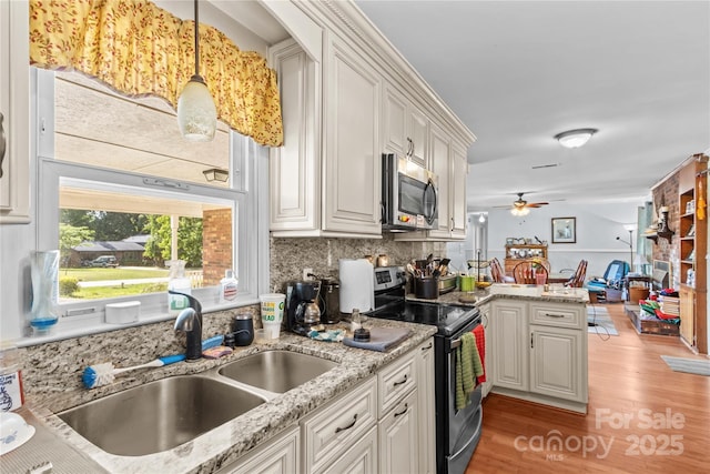 157 E Meadowview Dr, Statesville, NC 28625 - kitchen with appliances with stainless steel finishes, a sink, a peninsula, light wood finished floors, and backsplash