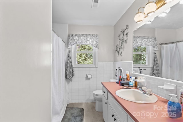 157 E Meadowview Dr, Statesville, NC 28625 - bathroom featuring tile walls, vanity, toilet, and a wainscoted wall