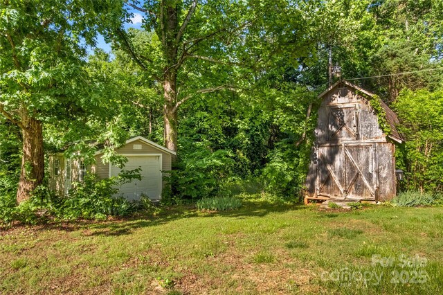 157 E Meadowview Dr, Statesville, NC 28625 - view of grassy yard with an outbuilding, a garage, and a storage shed