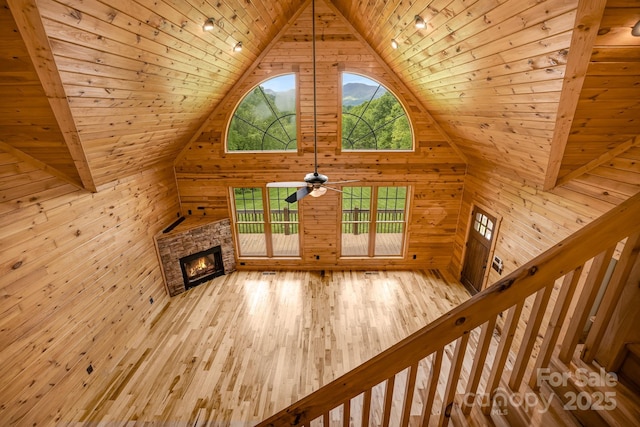 110 Mailon King Rd, Leicester, NC 28748 - unfurnished living room with wooden ceiling, wooden walls, vaulted ceiling, wood-type flooring, and a stone fireplace