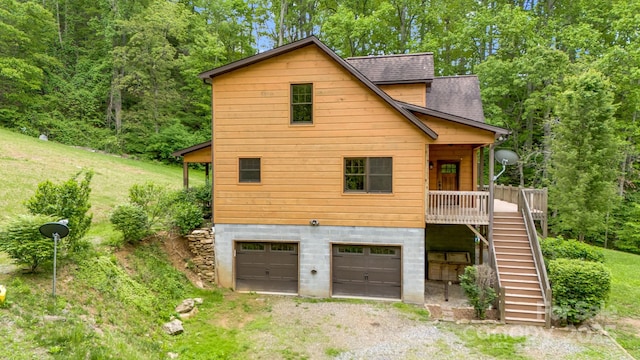 110 Mailon King Rd, Leicester, NC 28748 - back of property with stairway, dirt driveway, an attached garage, a shingled roof, and a wooden deck