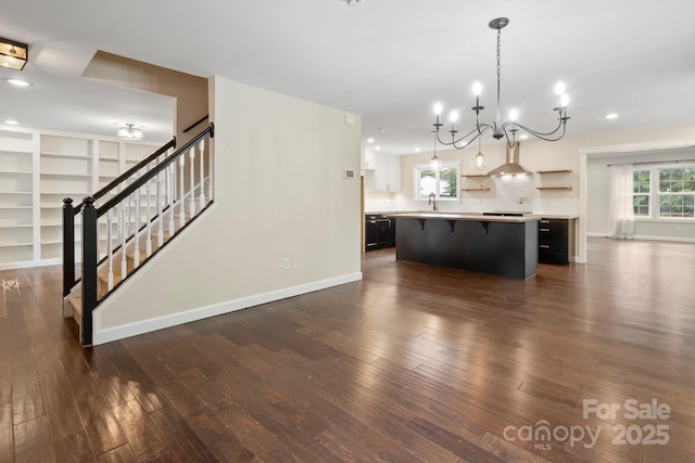 10749 Kingsview Dr, Davidson, NC 28036 - kitchen with light countertops, open shelves, a kitchen breakfast bar, a chandelier, and dark wood-type flooring