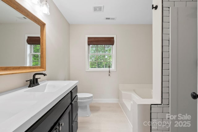 10749 Kingsview Dr, Davidson, NC 28036 - bathroom featuring baseboards, toilet, wood finished floors, a garden tub, and vanity
