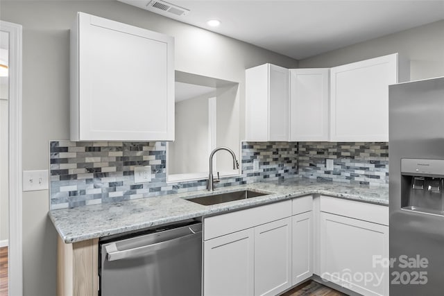 800 Hoyle St SW, Valdese, NC 28690 - kitchen with appliances with stainless steel finishes, a sink, white cabinetry, and decorative backsplash