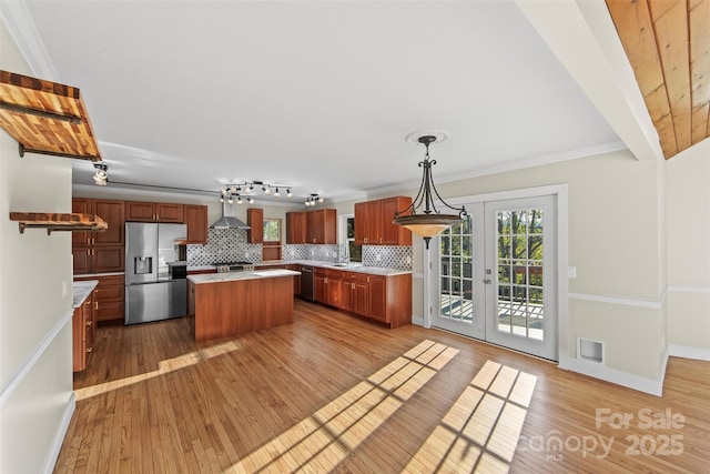 84 Halfmoon Way, Clyde, NC 28721 - kitchen featuring stainless steel appliances, light countertops, wall chimney range hood, decorative backsplash, and wood finished floors