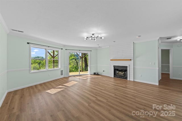 84 Halfmoon Way, Clyde, NC 28721 - unfurnished living room with ornamental molding, baseboards, a large fireplace, and wood finished floors