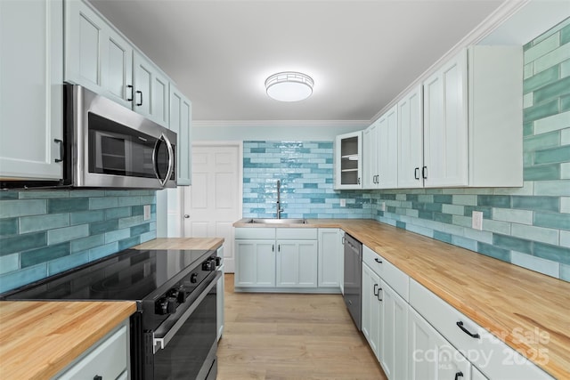84 Halfmoon Way, Clyde, NC 28721 - kitchen featuring butcher block countertops, stainless steel appliances, a sink, backsplash, and ornamental molding