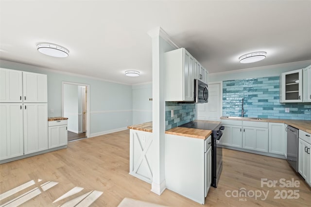 84 Halfmoon Way, Clyde, NC 28721 - kitchen with butcher block countertops, appliances with stainless steel finishes, ornamental molding, backsplash, and light wood finished floors