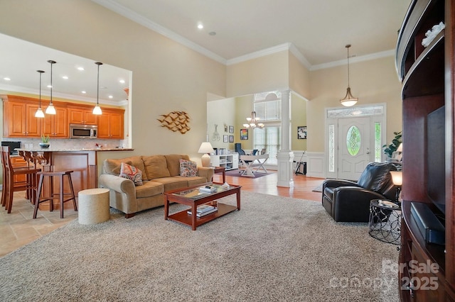 129 Daniel Efird Dr, Mount Holly, NC 28120 - living area featuring decorative columns, a chandelier, ornamental molding, recessed lighting, and a high ceiling