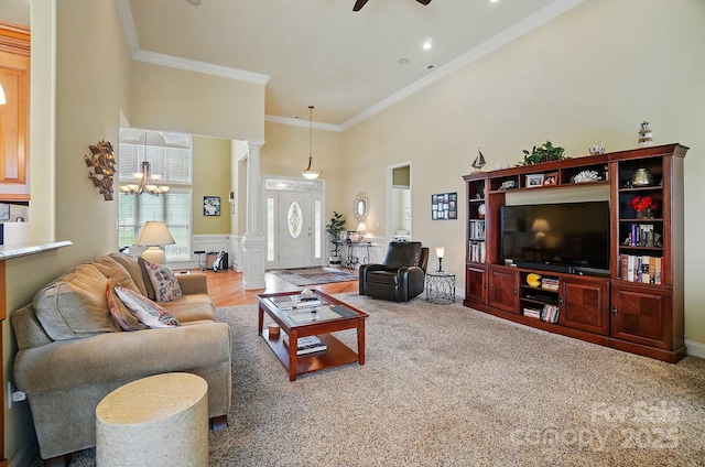 129 Daniel Efird Dr, Mount Holly, NC 28120 - living area with decorative columns, a towering ceiling, a ceiling fan, crown molding, and a chandelier