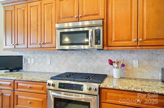 129 Daniel Efird Dr, Mount Holly, NC 28120 - kitchen featuring appliances with stainless steel finishes, light stone counters, and backsplash