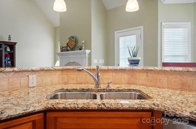 129 Daniel Efird Dr, Mount Holly, NC 28120 - kitchen view of a sink, brown cabinetry, light stone countertops, and pendant lighting