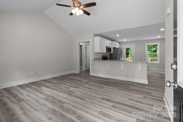 894 Oval St, Kannapolis, NC 28081 - unfurnished living room with a ceiling fan, recessed lighting, light wood-style flooring, lofted ceiling, and baseboards