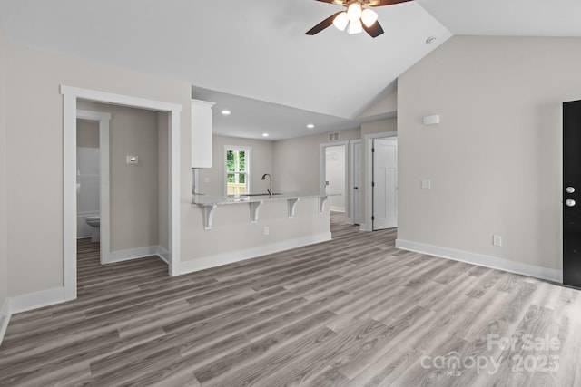 894 Oval St, Kannapolis, NC 28081 - unfurnished living room featuring a ceiling fan, light wood-type flooring, vaulted ceiling, recessed lighting, and baseboards