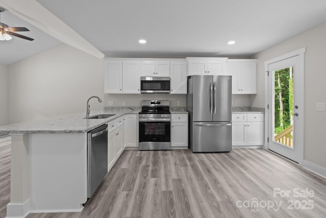 894 Oval St, Kannapolis, NC 28081 - kitchen featuring appliances with stainless steel finishes, a sink, light wood-style flooring, a peninsula, and white cabinets