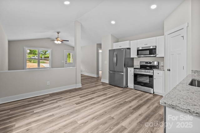 896 Oval St, Kannapolis, NC 28081 - kitchen featuring appliances with stainless steel finishes, white cabinetry, a ceiling fan, vaulted ceiling, and light wood-type flooring
