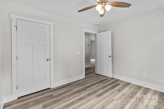 896 Oval St, Kannapolis, NC 28081 - unfurnished bedroom with light wood-style flooring, baseboards, and a ceiling fan