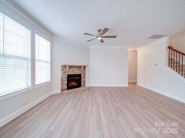 unfurnished living room with light wood-style flooring, ceiling fan, healthy amount of natural light, stairs, and ornamental molding