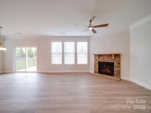 unfurnished living room featuring ornamental molding, ceiling fan, light wood-style flooring, baseboards, and a stone fireplace