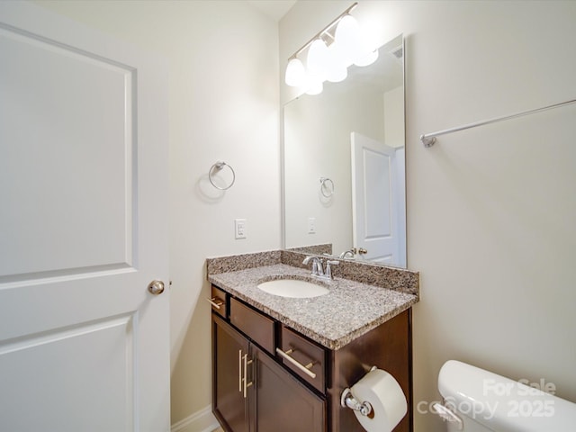 half bathroom featuring vanity and toilet