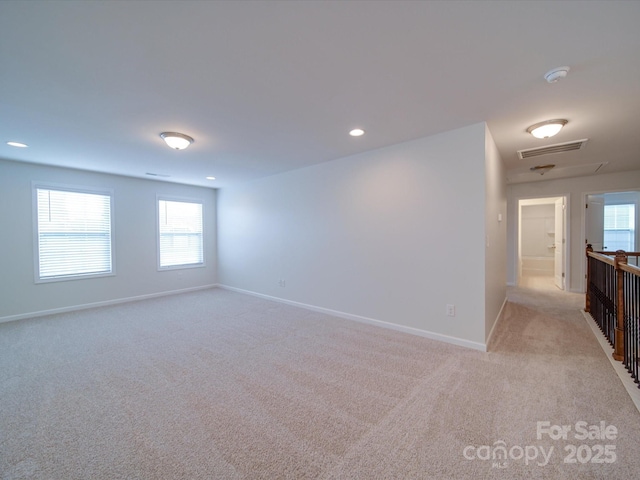 empty room with light colored carpet, baseboards, and recessed lighting