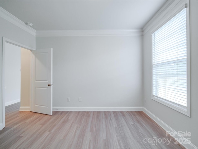 unfurnished room featuring light wood finished floors, crown molding, and baseboards