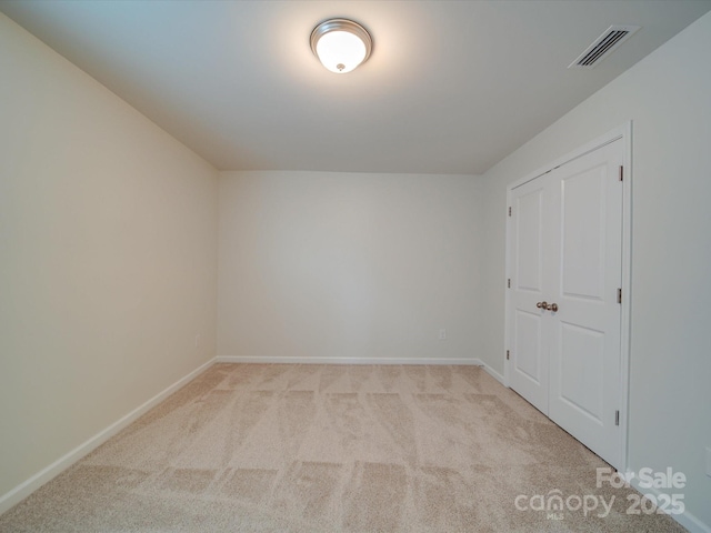 unfurnished bedroom featuring light colored carpet and baseboards