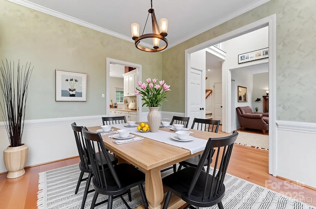 4619 Glasgow Ct, Gastonia, NC 28056 - dining room with light wood-type flooring, a chandelier, wallpapered walls, crown molding, and wainscoting