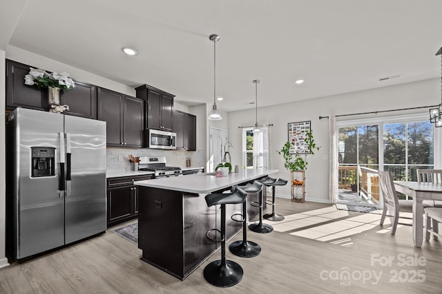 2665 Grantham Place Dr, Fort Mill, SC 29715 - kitchen featuring stainless steel appliances, light wood-style flooring, tasteful backsplash, light countertops, and recessed lighting