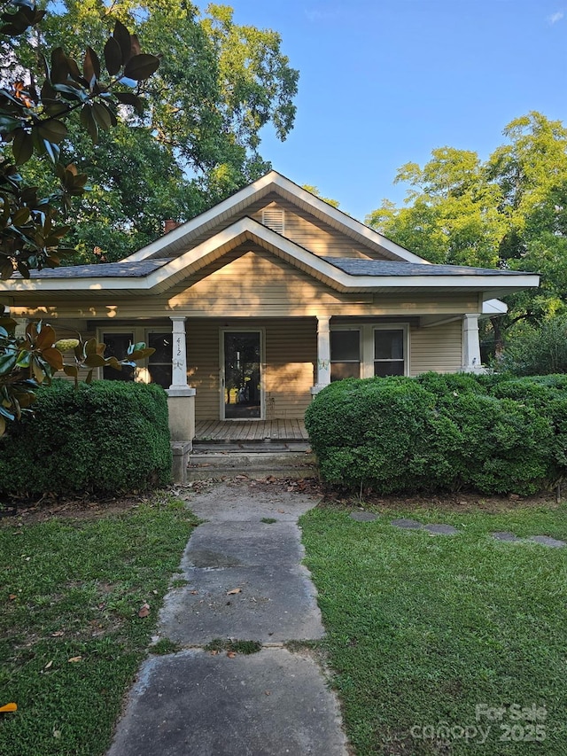 view of front of property with covered porch and a front yard