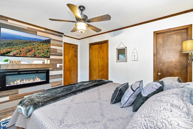 301 Pinnacle Inn Rd Unit 2210, Beech Mountain, NC 28604 - bedroom featuring ornamental molding, a textured ceiling, a glass covered fireplace, and a ceiling fan