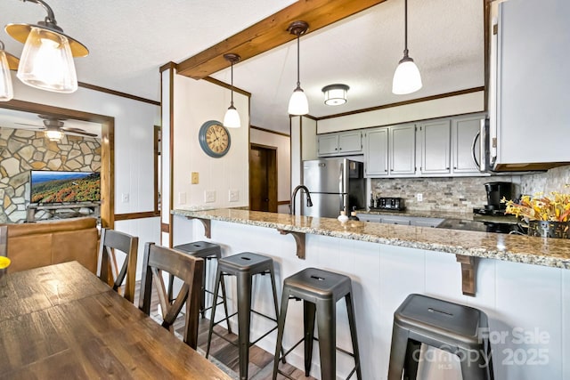 301 Pinnacle Inn Rd Unit 2210, Beech Mountain, NC 28604 - kitchen featuring stainless steel appliances, a peninsula, light stone counters, tasteful backsplash, and ornamental molding