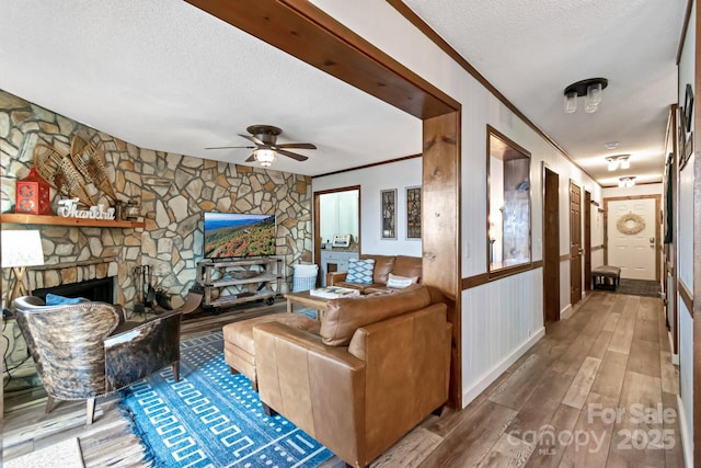 301 Pinnacle Inn Rd Unit 2210, Beech Mountain, NC 28604 - living area featuring crown molding, wood finished floors, a textured ceiling, a ceiling fan, and a fireplace