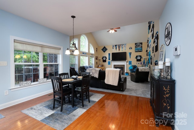 201 Vanderbilt Blvd, Locust, NC 28097 - dining space with ceiling fan, wood finished floors, lofted ceiling, a fireplace, and baseboards