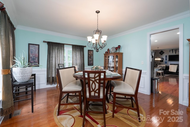 201 Vanderbilt Blvd, Locust, NC 28097 - dining space with ornamental molding, wood finished floors, a chandelier, and wainscoting