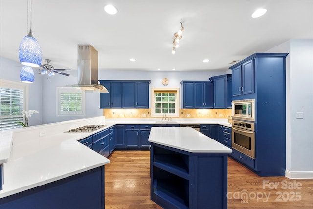 5418 Commodore Pl, Clover, SC 29710 - kitchen featuring appliances with stainless steel finishes, island exhaust hood, blue cabinets, a sink, and light countertops