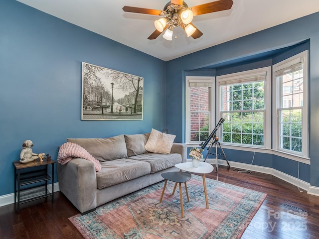 living room with hardwood / wood-style floors, baseboards, and a ceiling fan