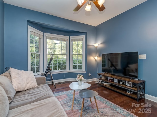 living room with baseboards, wood finished floors, and a ceiling fan