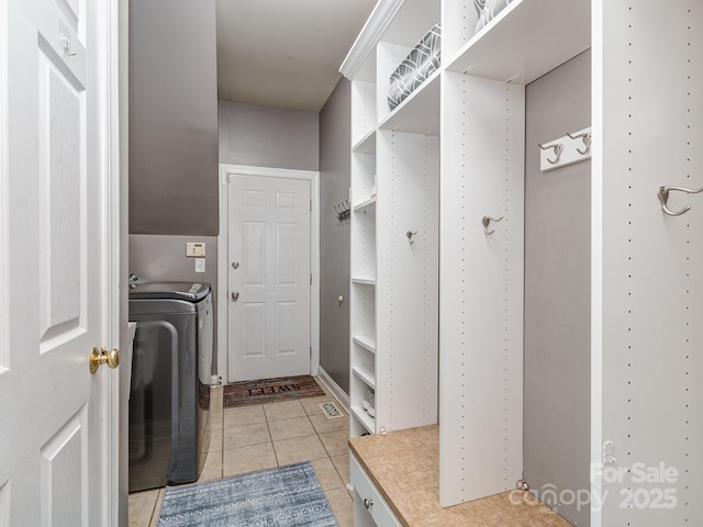 clothes washing area featuring light tile patterned flooring and washing machine and dryer