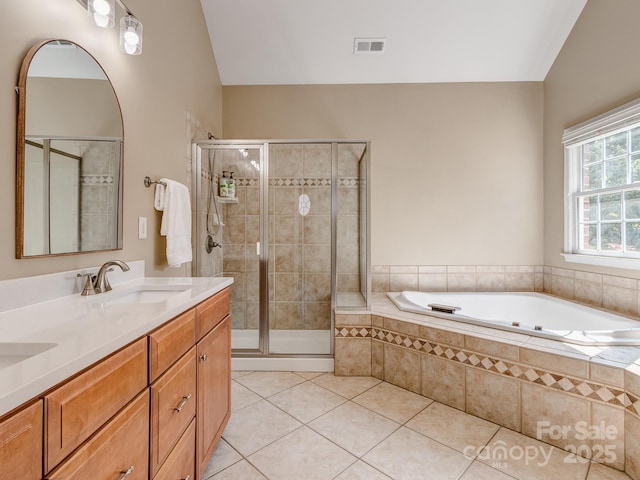 full bath featuring tile patterned flooring, vaulted ceiling, a shower stall, a bath, and double vanity