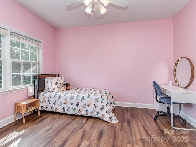 bedroom featuring wood finished floors, baseboards, a desk, and ceiling fan
