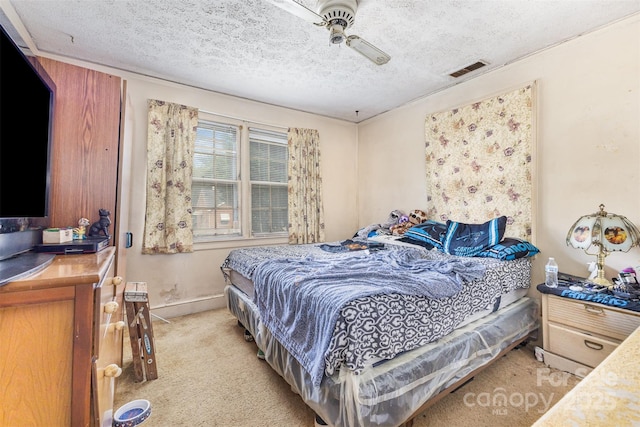 bedroom featuring light carpet, a textured ceiling, baseboards, and a ceiling fan