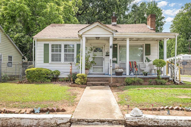view of front of property featuring a chimney, a porch, and roof with shingles