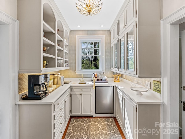 bar featuring dishwashing machine, tasteful backsplash, a chandelier, a sink, and recessed lighting