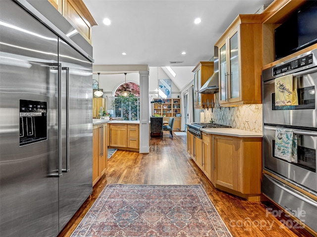kitchen featuring appliances with stainless steel finishes, a warming drawer, dark wood-style floors, light countertops, and glass insert cabinets